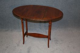 A small Edwardian mahogany oval Pembroke table with fruitwood stringing, supported on square