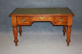 A Victorian mahogany desk with inset top, below three drawers supported on turned tapering legs,