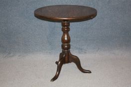 An oak circular tilt top tripod table. 69 cm diameter