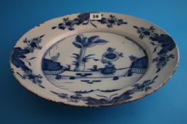 An 18th century tinglaze earthenware blue and white charger decorated with trees and flowers. 34 cm
