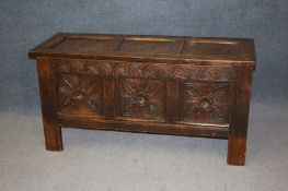 A 19th century oak coffer with 3 panelled top and 3 carved panels to the front. 130 cm long