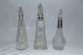 Group of three silver mounted cut glass dressing table bottles, various makers, dates and assay