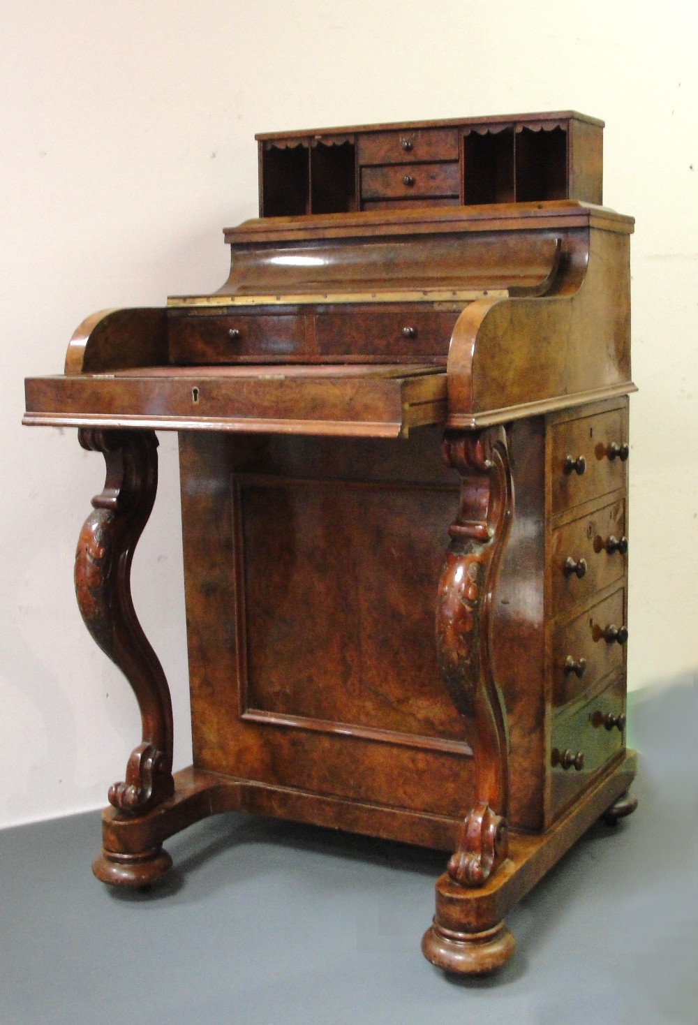 A Davenport:
19th century, walnut, the top with a lifting drawer and pigeon hole arrangement, the