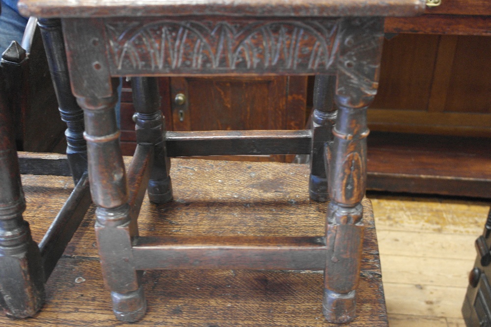 A 17th Century Oak Joint Stool:
the rectangular top above a carved lunette frieze on turned and - Image 2 of 3