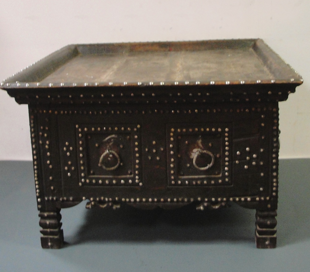 A Table:
19th century, Middle Eastern, hardwood of square form with studwork & ring handles to