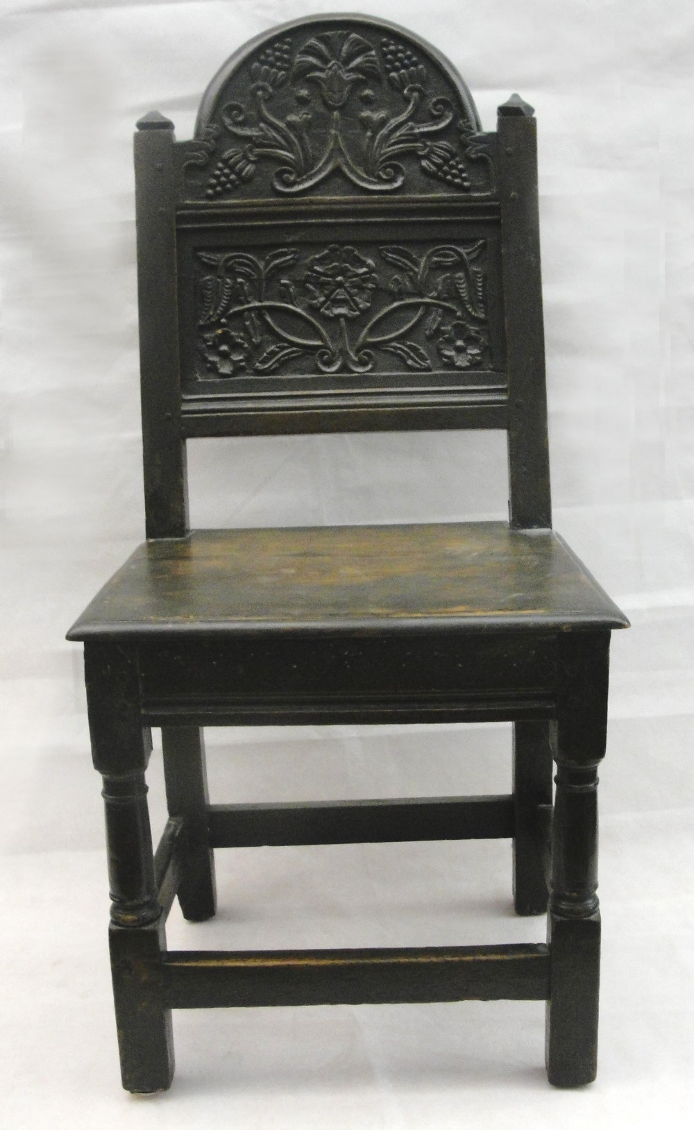 A 17th Century and Later Oak Chair:
the arched back carved with a thistle and rose.   On turned legs