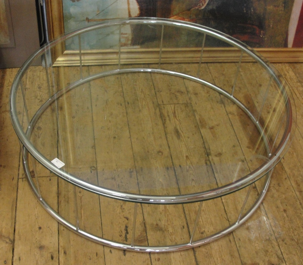 A circular chrome glass top table