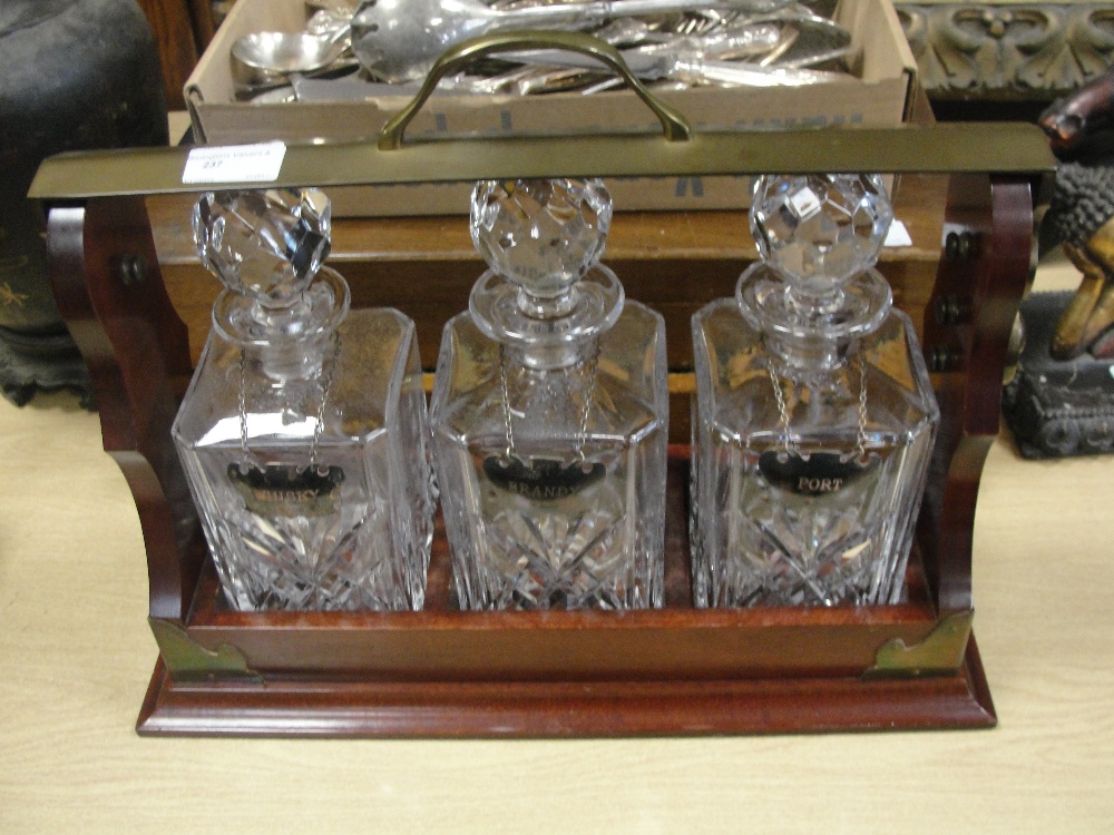 An oak tantalus and decanters with HM silver drinks labels