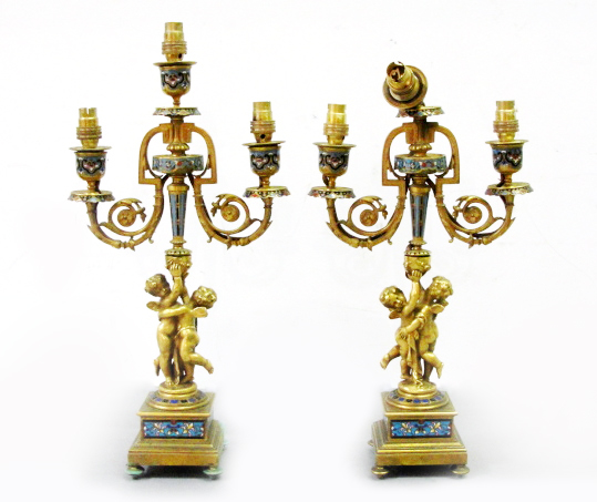 A Pair of 19th Century Enamelled Ormolu Cherub Candelabra:
a triple sconce candelabra with winged