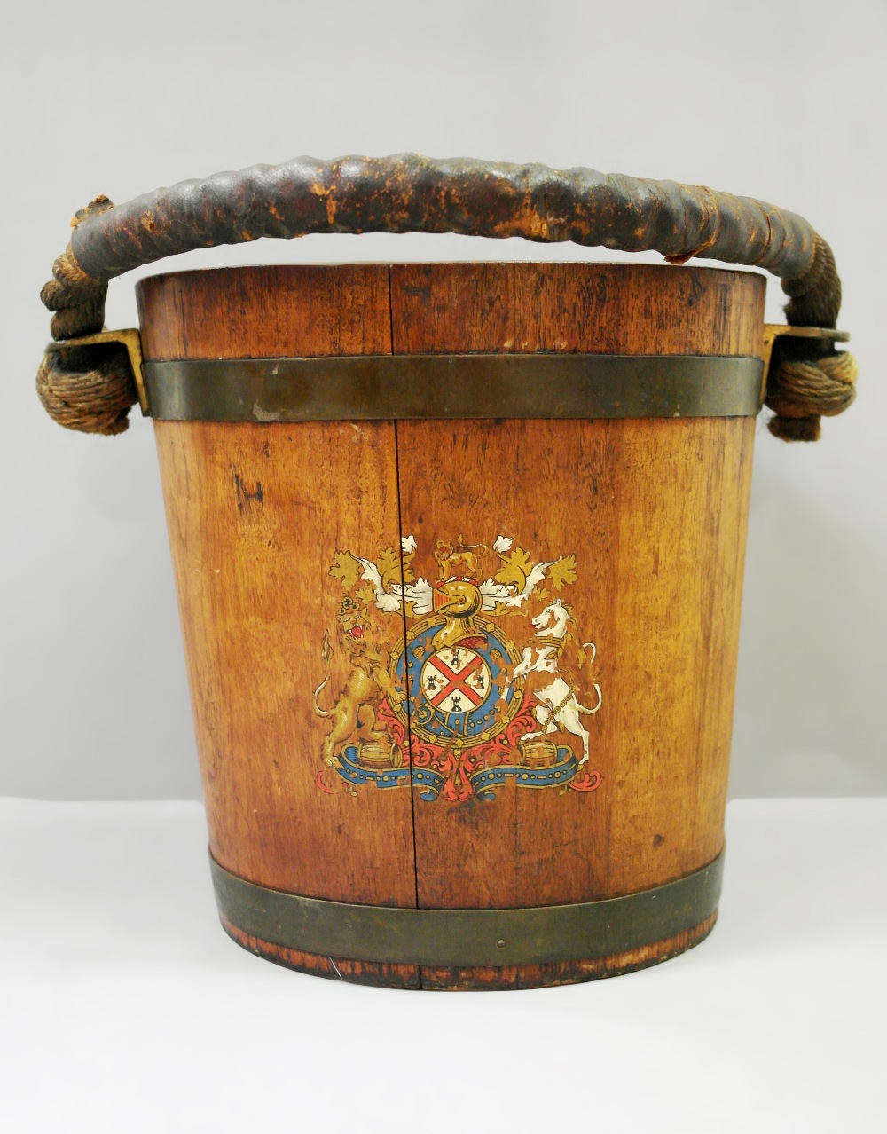 A 19th Century Teak Fire Bucket:
made from teak with brass banding.  The handle is constructed of