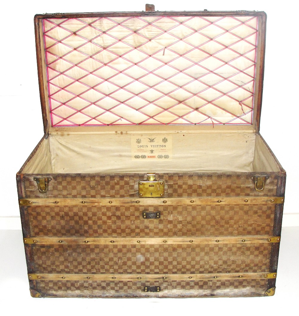 A Louis Vuitton Trunk:
19th century the whole decorated with cloth cube design, the top with brass &