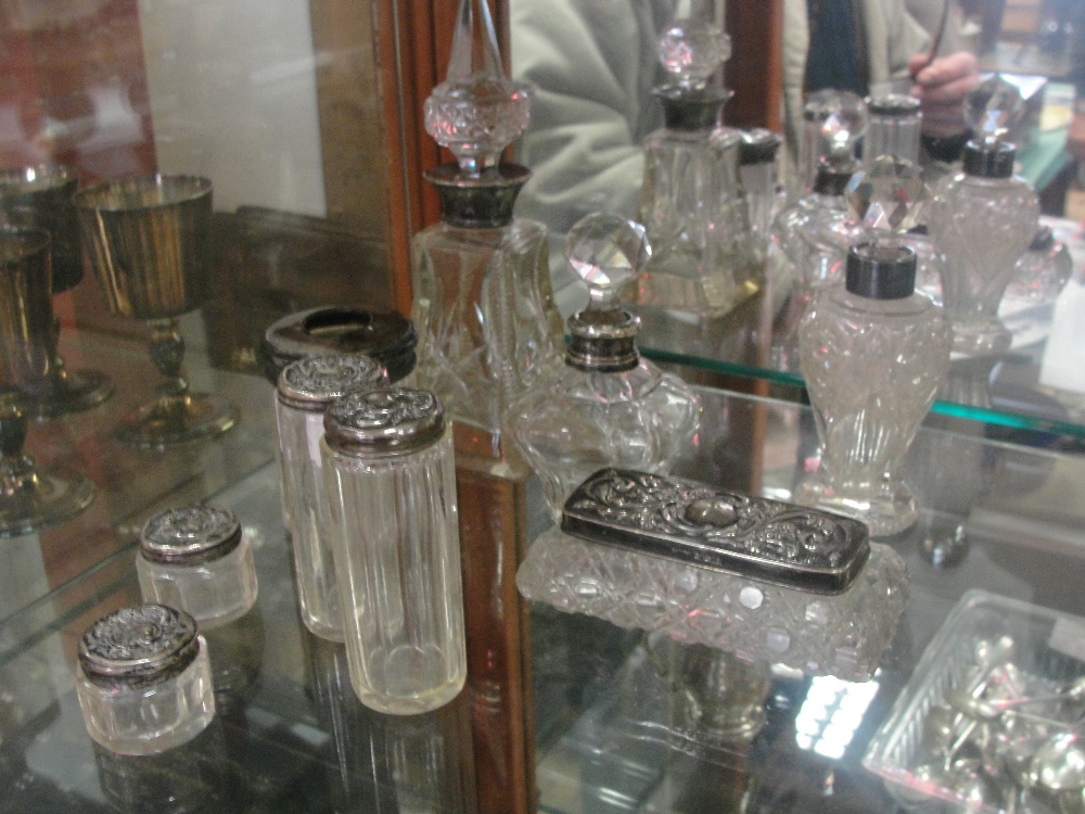 A quantity of 19th century and later HM silver perfume bottles; together with silver topped glass