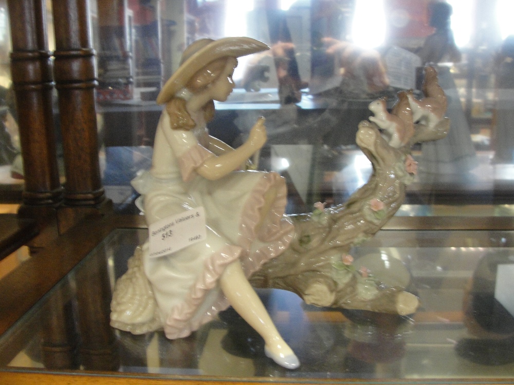 A Lladro figure of a girl sitting on a log