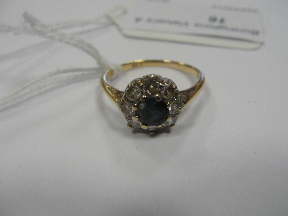 A diamond and sapphire daisy ring