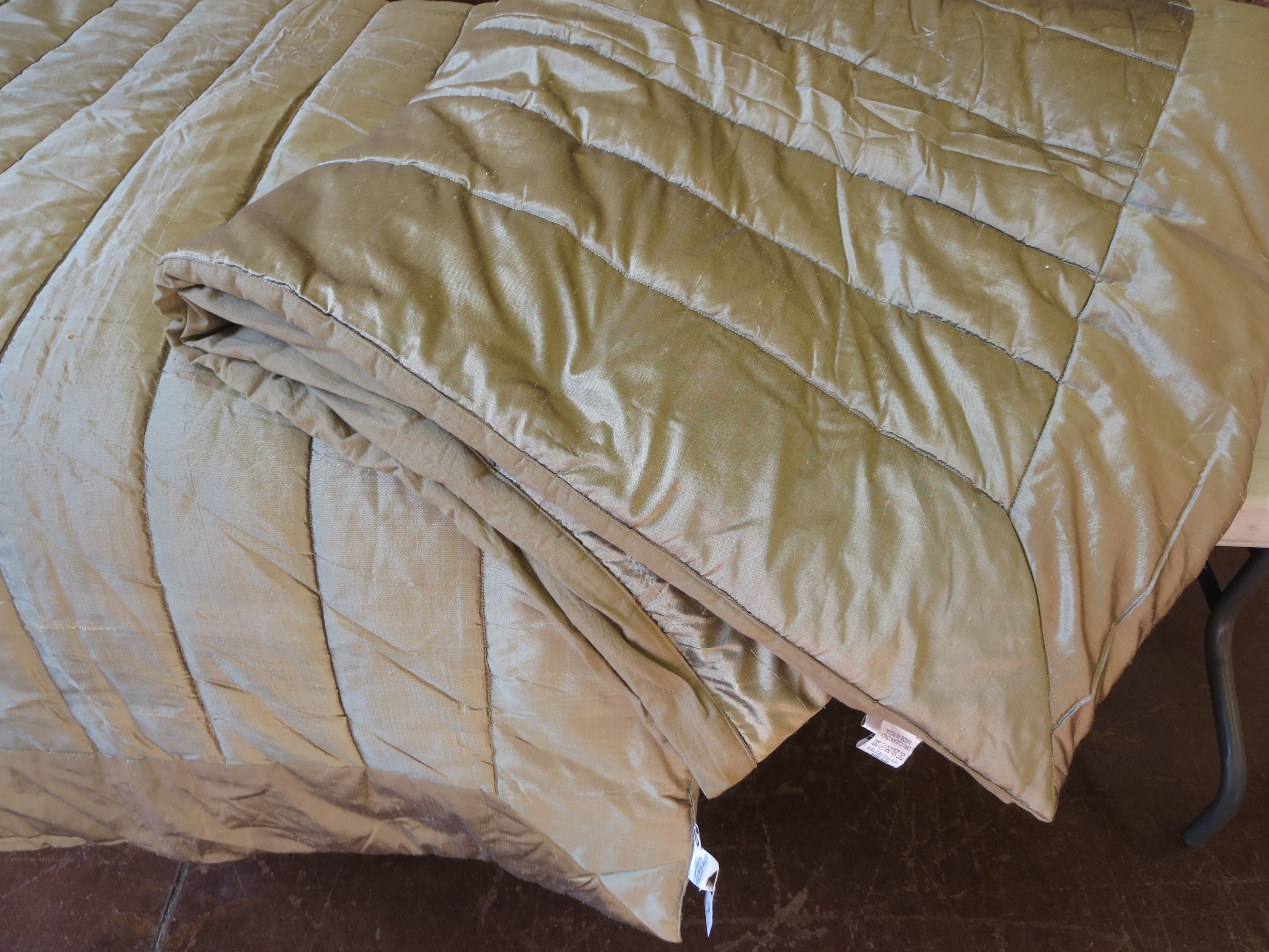 A pair of quilted silk single bed covers