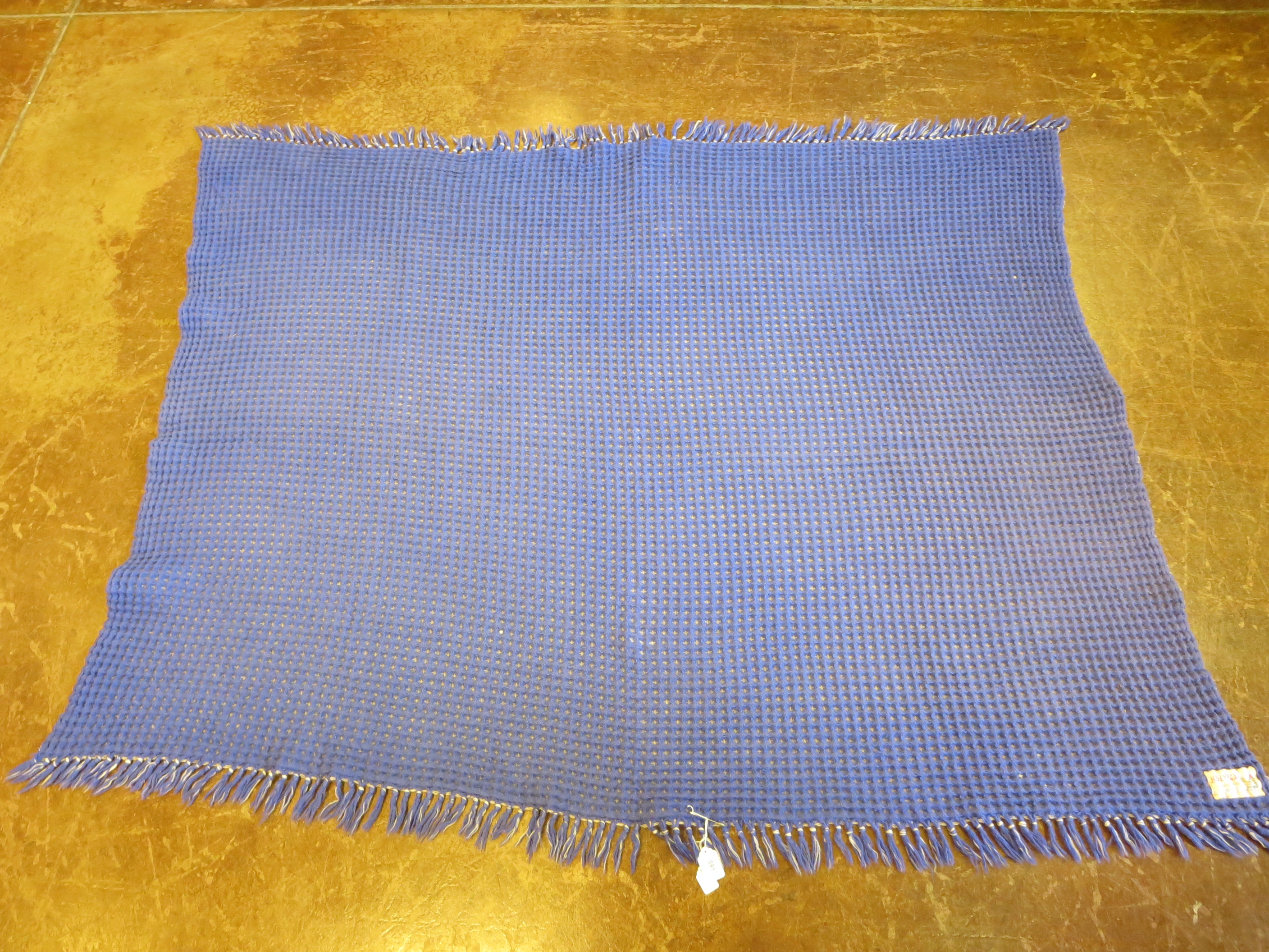 A blue and white honeycomb woven Welsh blanket