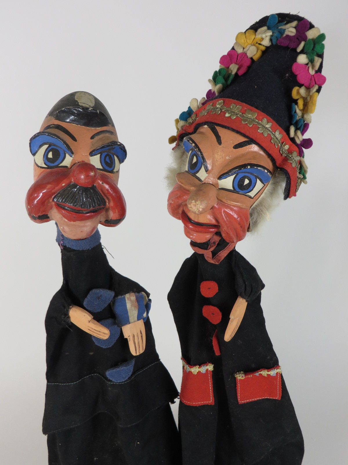 Two professionally carved stylised wooden glove puppets with original costumes. One representing a