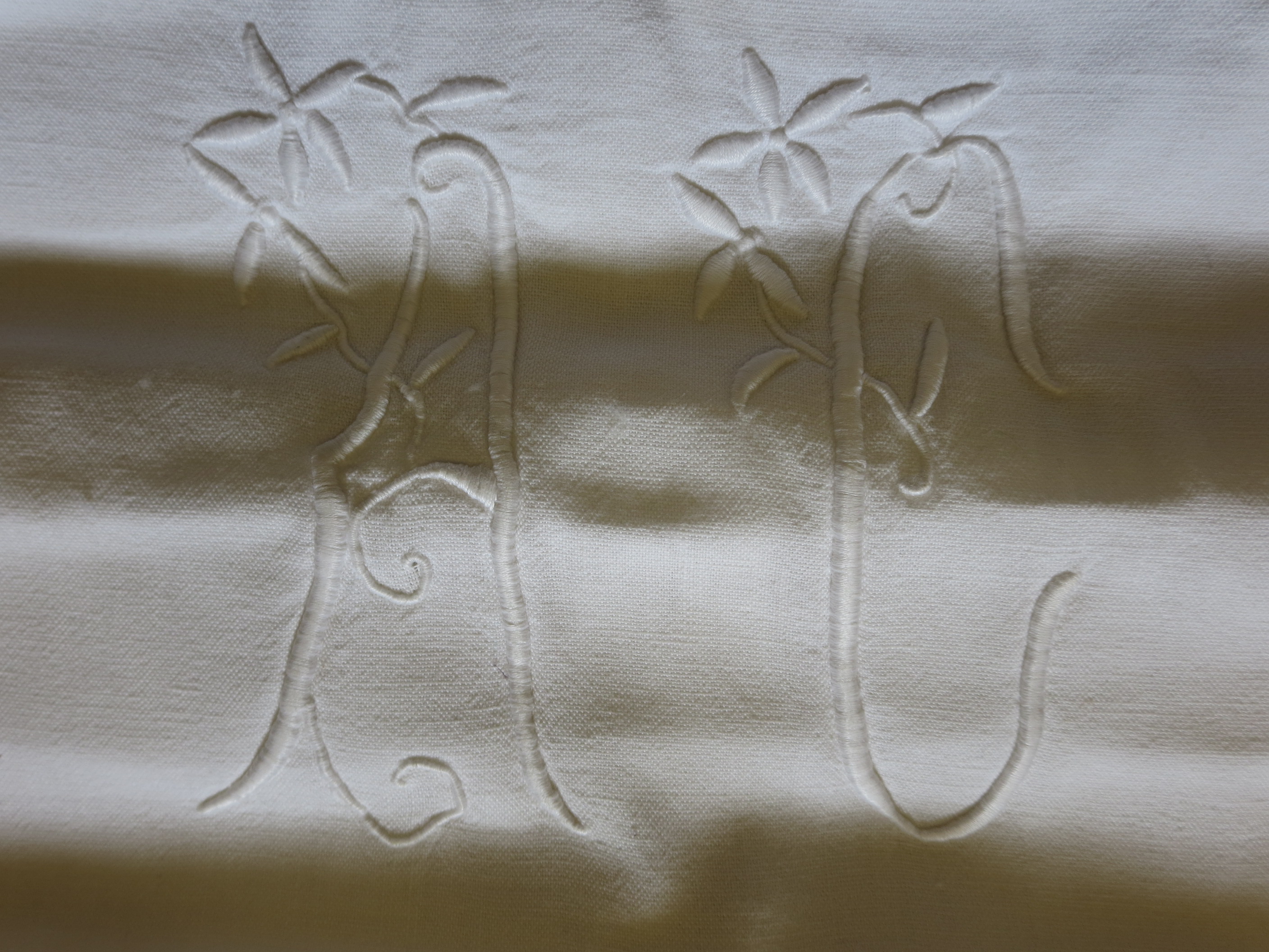A roman blind made from a white French sheet with a monogram. 54 x 54in