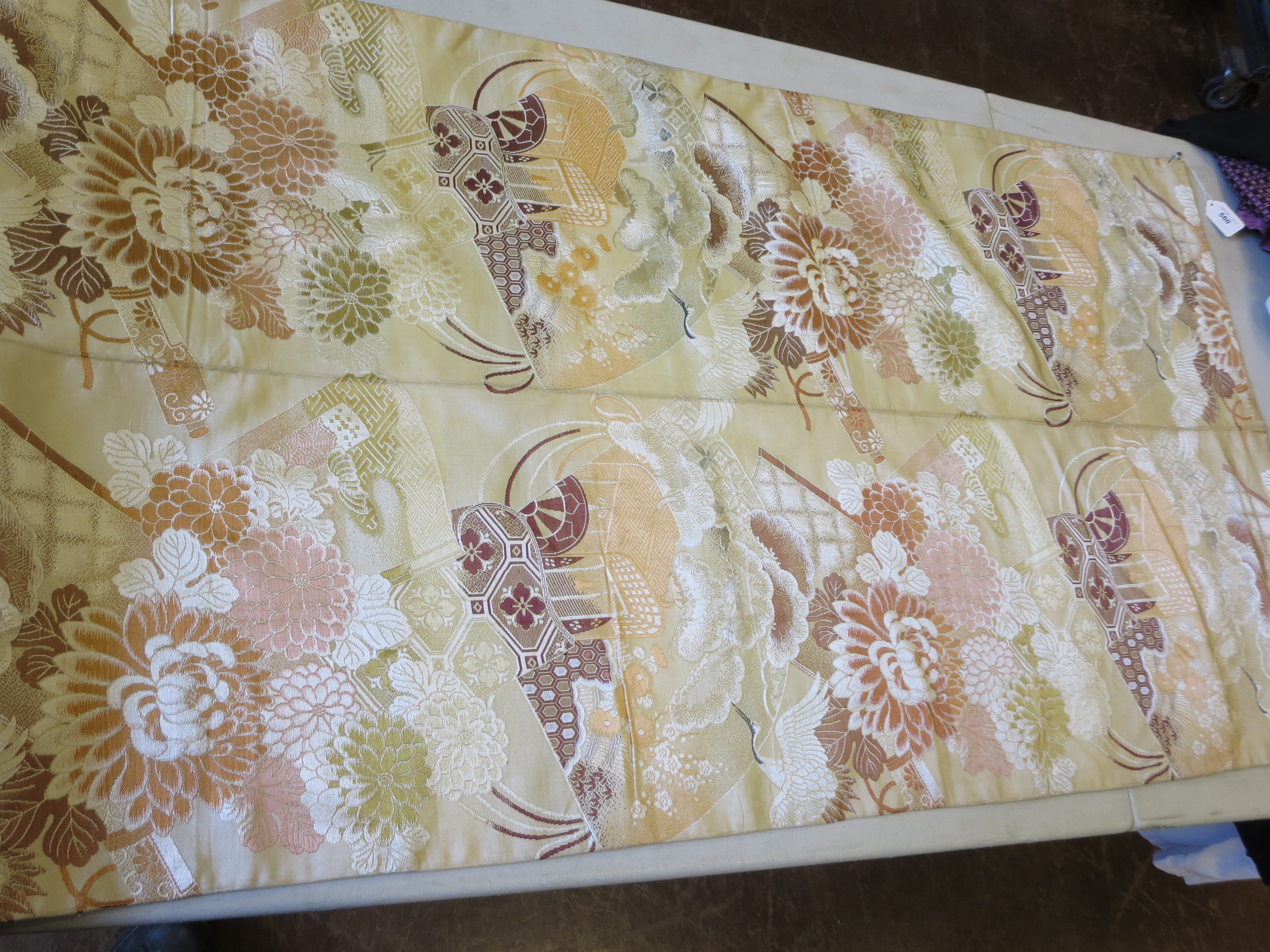 A part roll of Japanese metallic brocade, fan and flower pattern on a cream ground