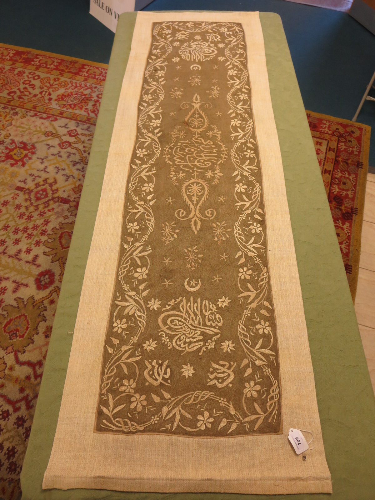 An antique gold embroidered Islamic hanging with scroll work and Islamic letters. Later backing.