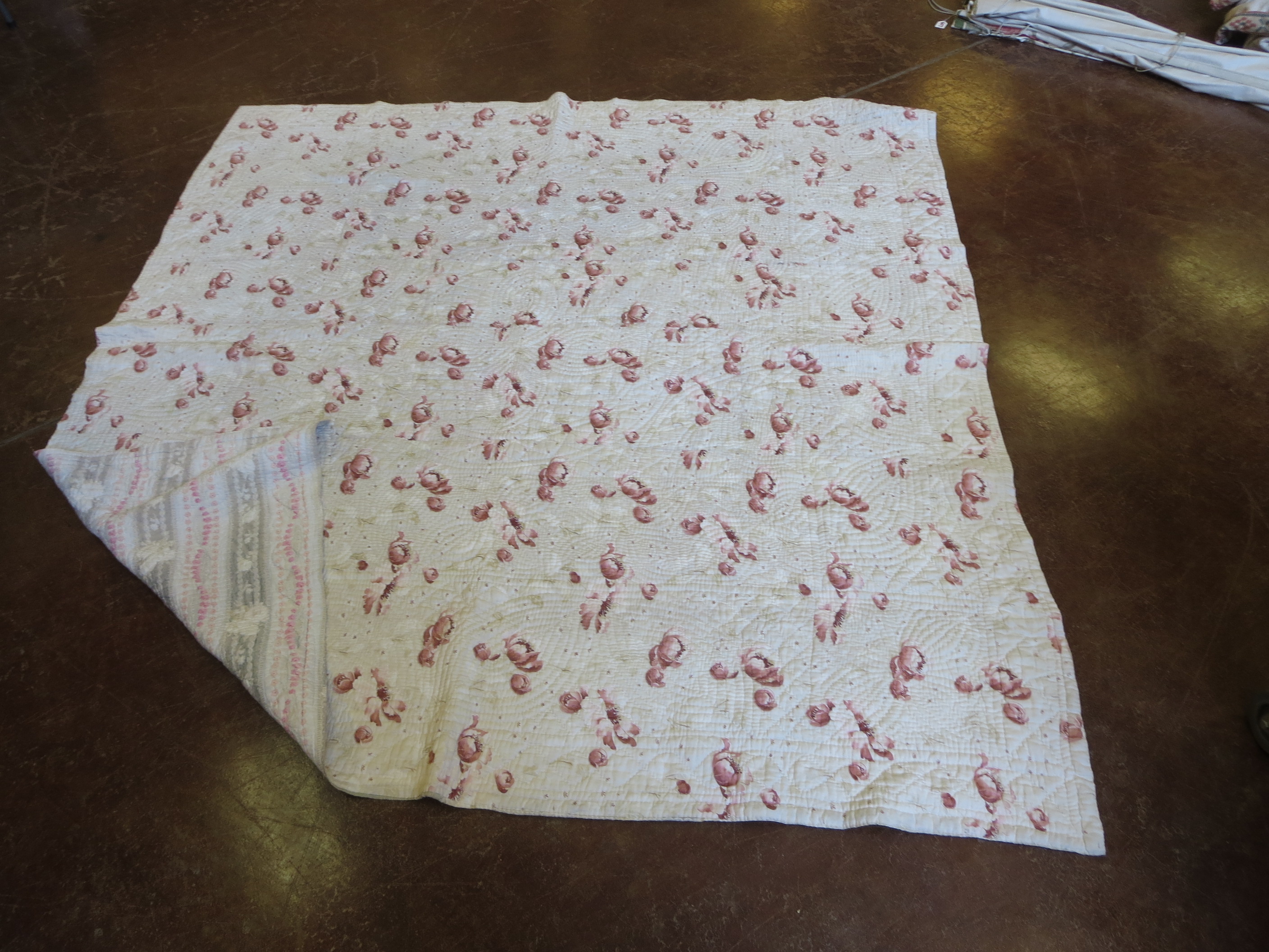 A large Welsh quilt with crimson flowered pattern to one side and striped flowers verso. Circa 1890