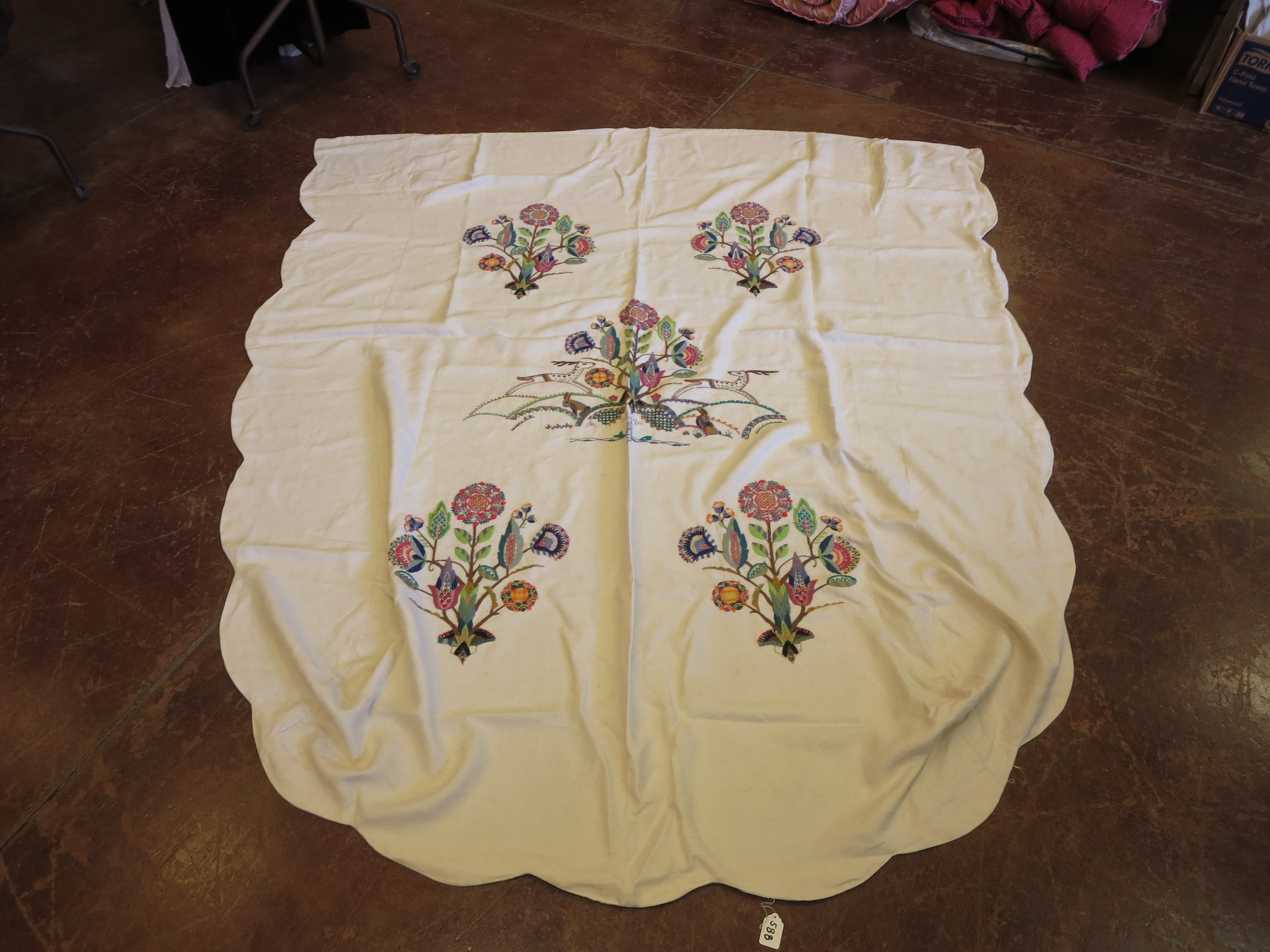 A wool on linen English crewelwork bed cover. The stylised rabbits and flowers worked in a variety