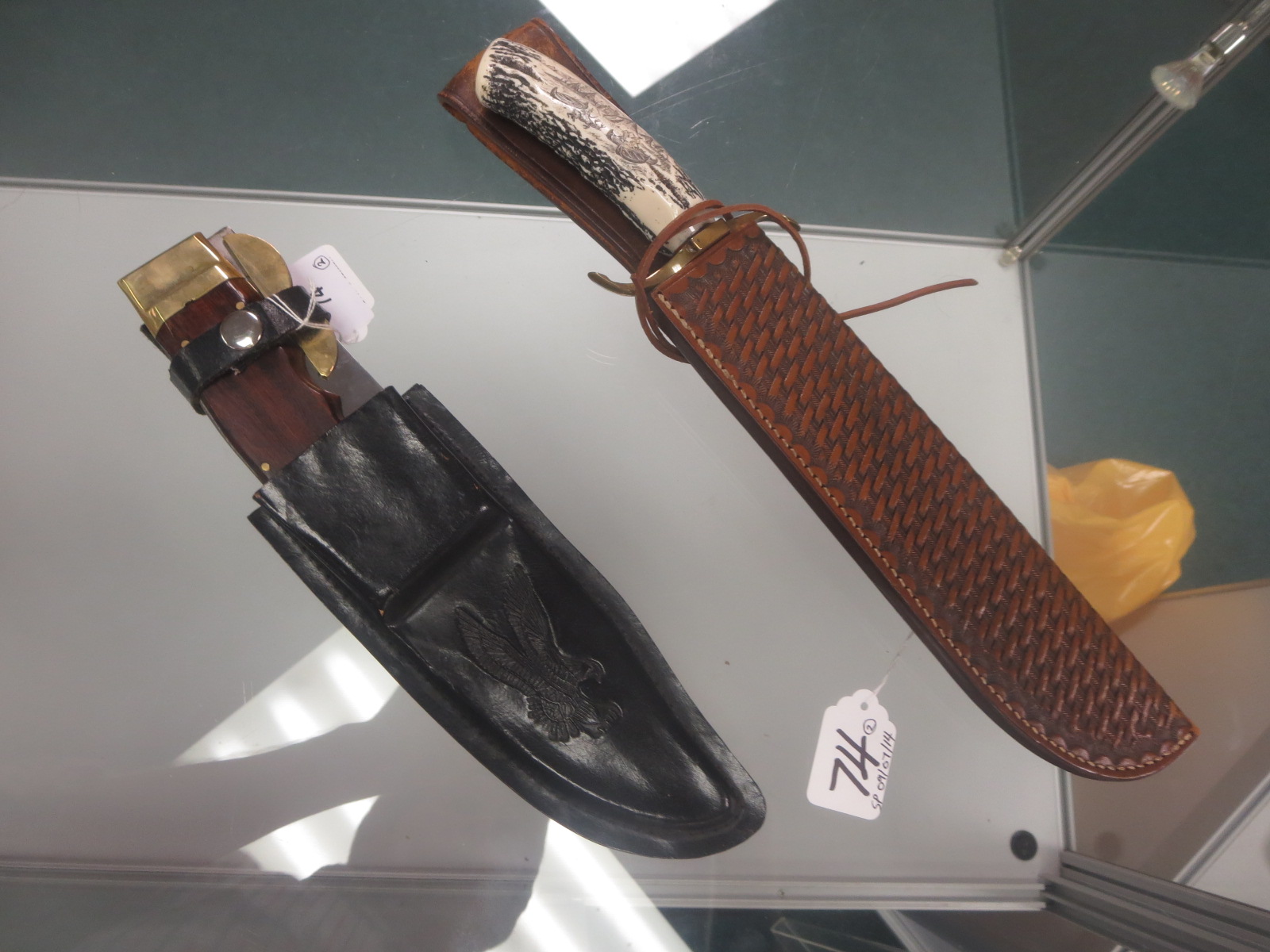 A folding Hunting Knife with brass mounts and leather sheath, and another with resin ‘antler’