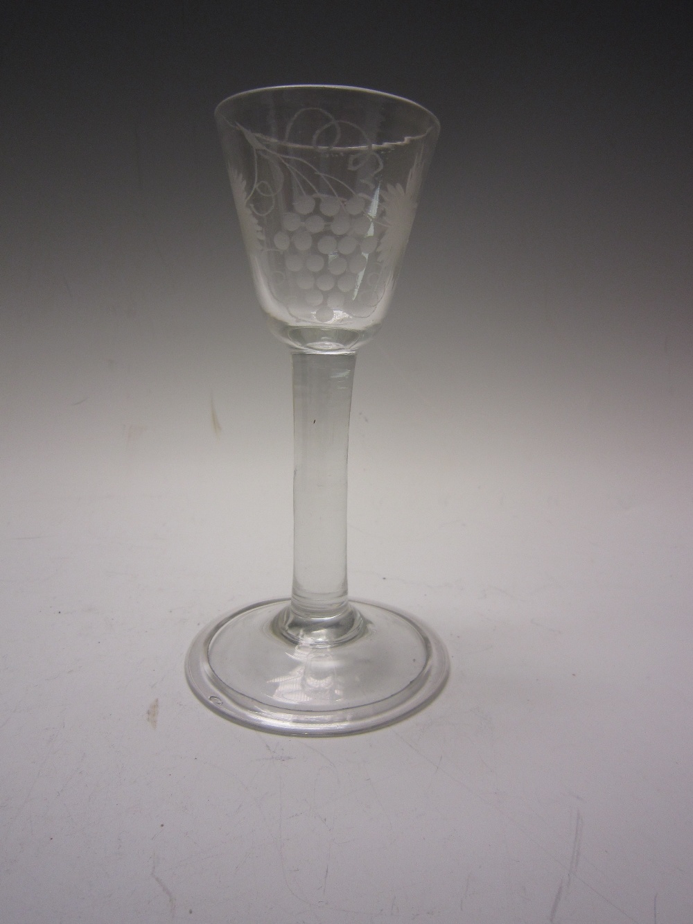 An 18th Century Wine Glass with round funnel bowl etched fruiting vine, on plain gun barrel stem and
