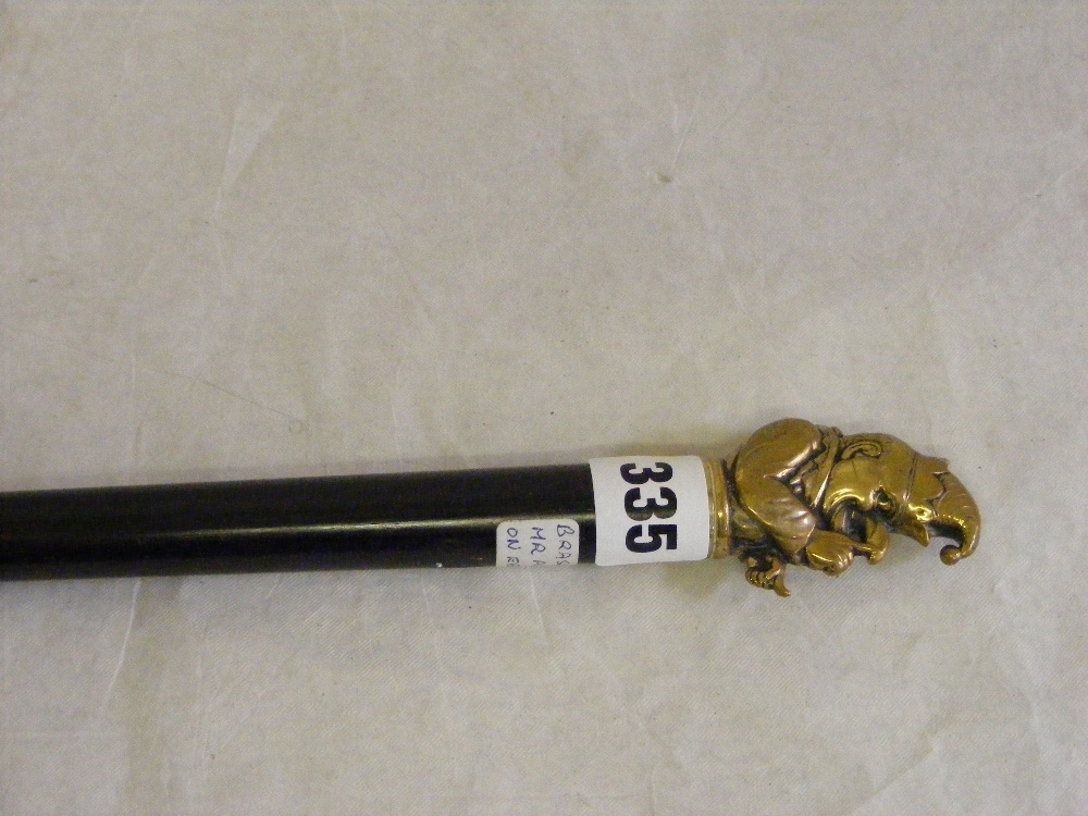 An ebonised walking stick with brass handle in the form of Mr Punch.