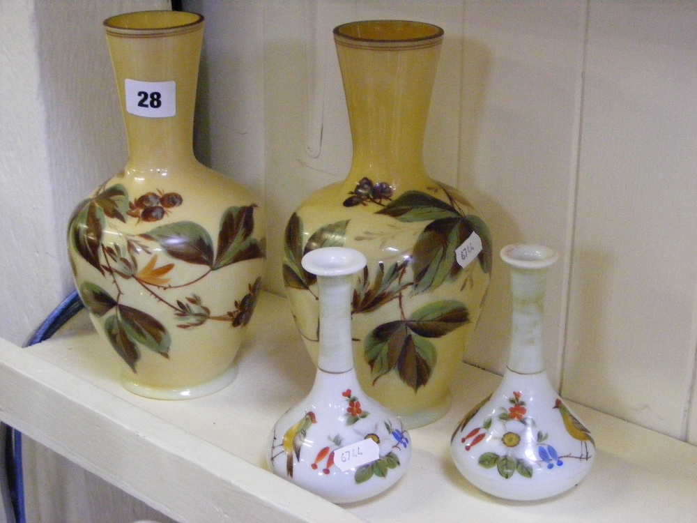 A pair of very pretty hand painted glass vases decorated with leaves on a yellow ground, together