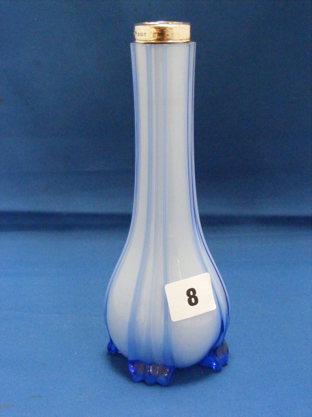 A silver topped blue glass bud vase of shaped elongated form.