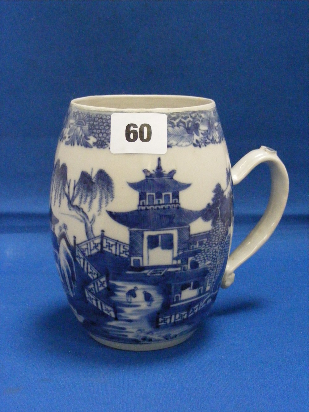 A large Oriental antique blue and white tankard with landscape decoration.