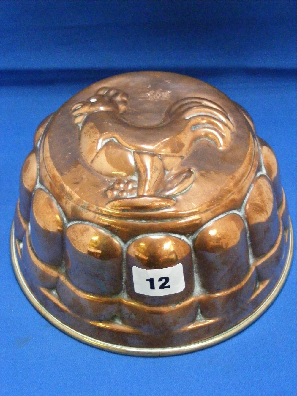 An antique copper jelly mould, the base depicting a chicken.