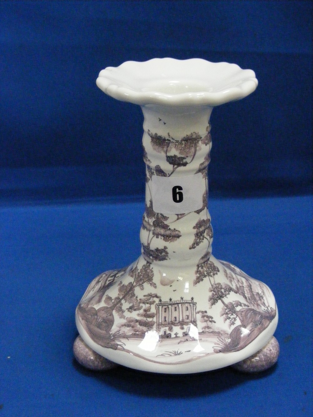 A hand painted ceramic candlestick depicting in lilac and white Highgrove House, the country home of