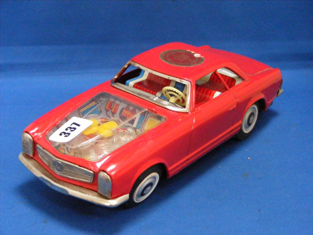 A Japanese Asahi battery operated tinplate car with Perspex bonnet and tin printed red, blue and