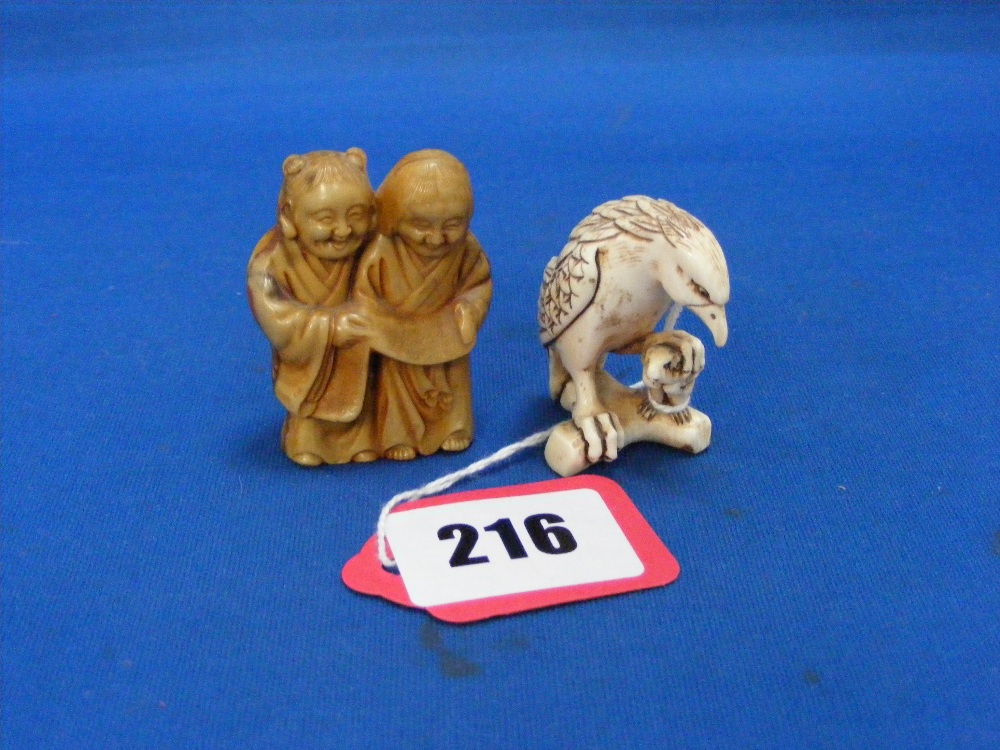 A Japanese carved ivory Netsuke of an eagle holding a rat in its claw, plus a stained carving of two