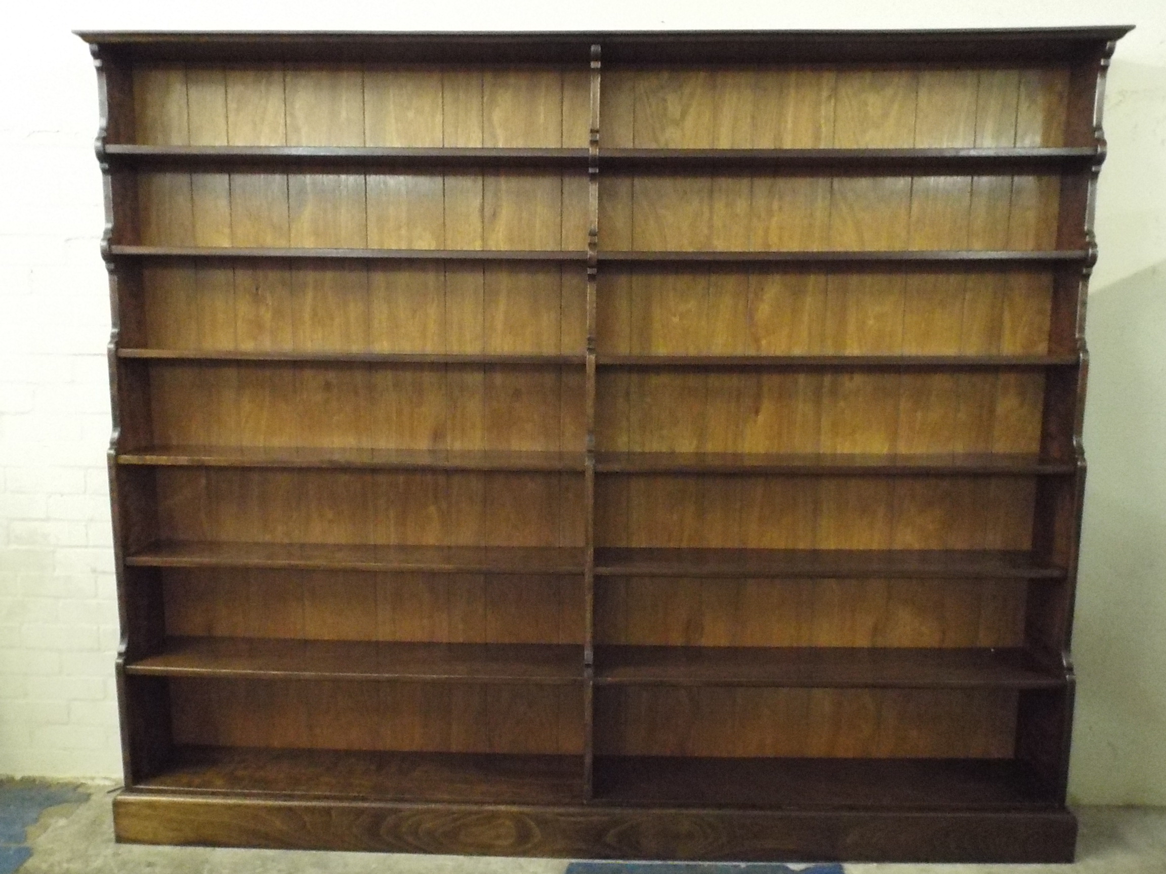 A Large Contemporary Two Division Seven Shelf Waterfall Bookcase with Plinth Base. 242cm Wide