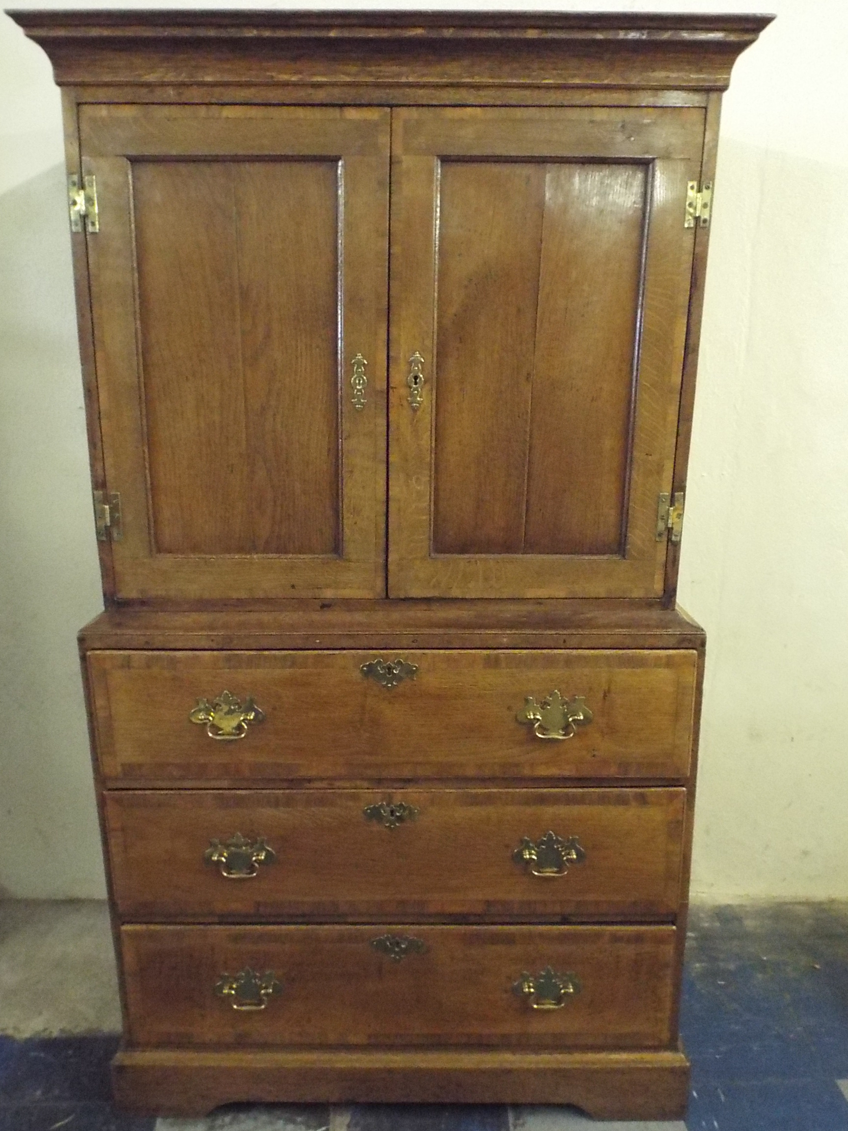 A 19th Century Oak and Mahogany Crossbanded Linen Press. The Base with Three Graduated Long