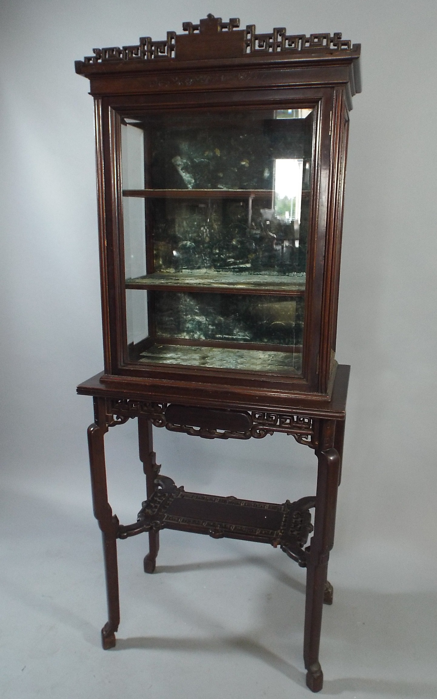 An Oriental Glazed Display Cabinet on Carved and Pierced Stand with Stretcher Shelf. The Top Section