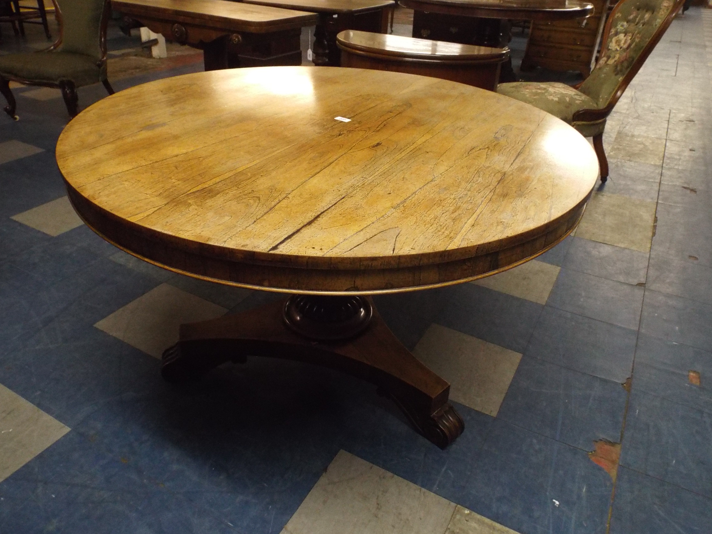 A 19th Century Rosewood Circular Breakfast Table with Triform Base and Scrolled Feet.