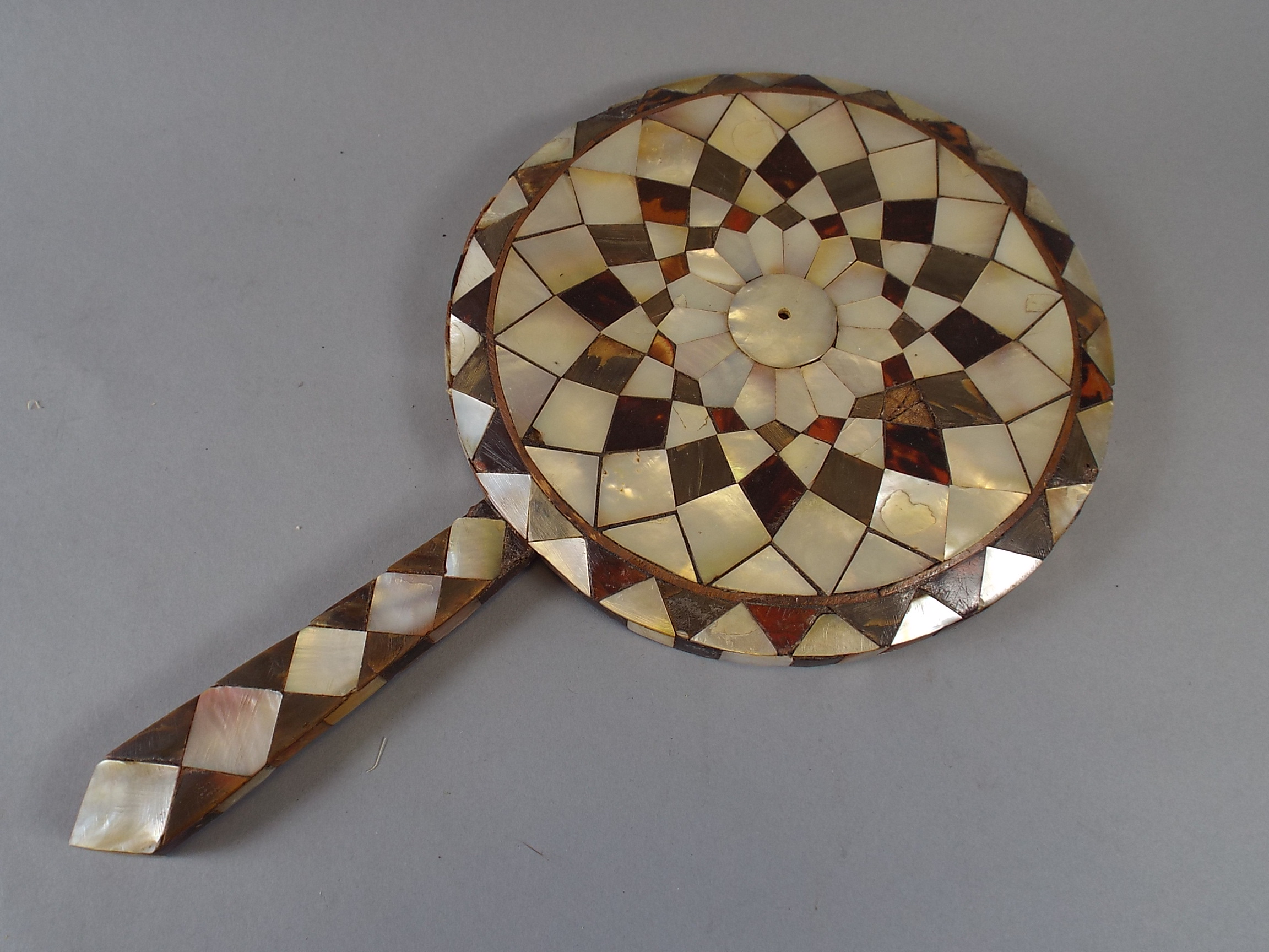 An Eastern Tortoiseshell and Mother of Pearl Hand Mirror Frame. 19.5cm Diameter    CONDITION REPORT:
