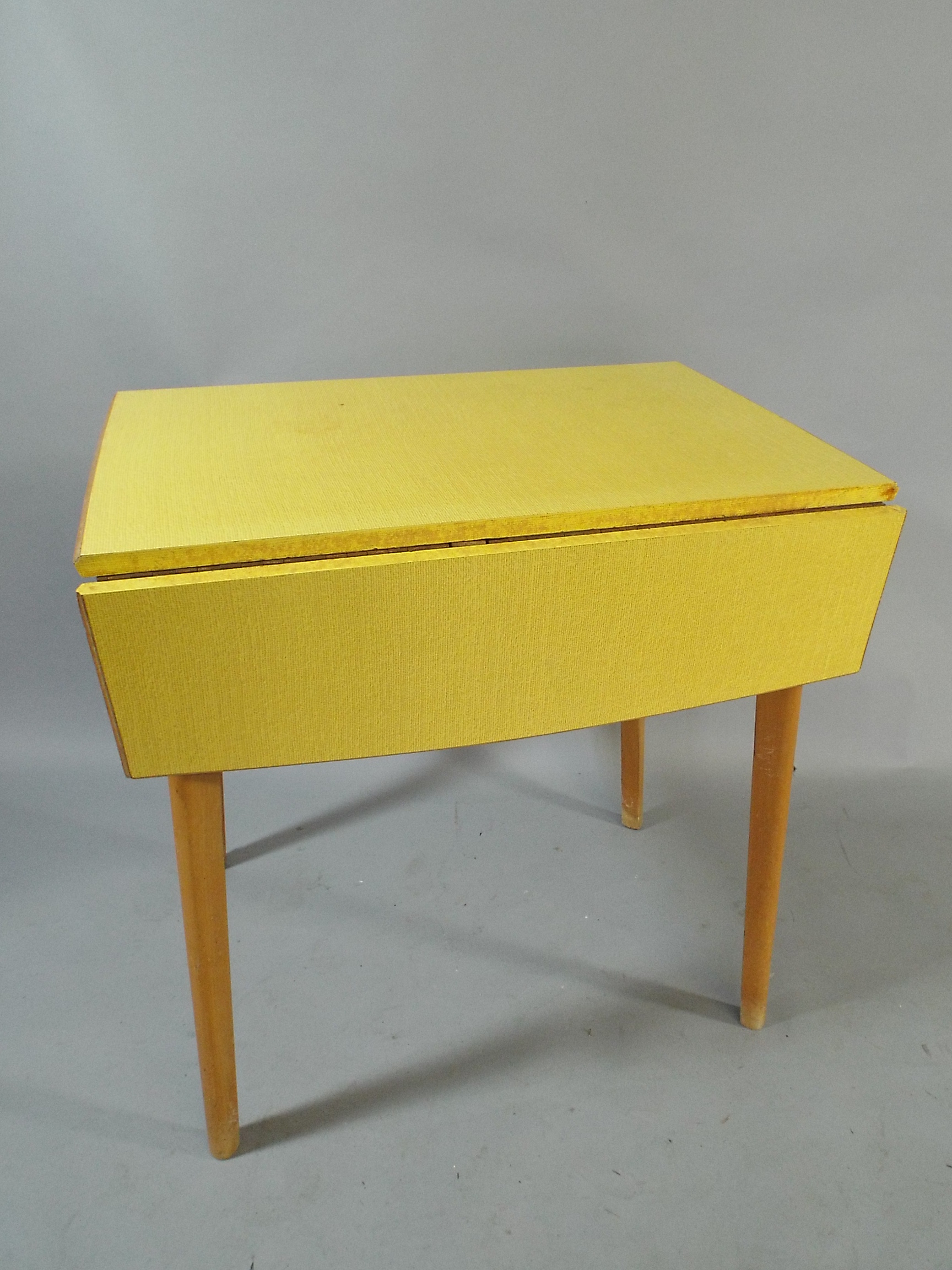 A 1950/60s Drop Leaf Kitchen Table with Yellow Formica Top, 76x54cm with Leaves Folded.