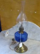 A brass and blue glass oil lamp, converted to electricity, with funnel.