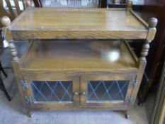 An Old Charm oak buffet on castors, shelf to the top with shelf below with astral glazed cupboard