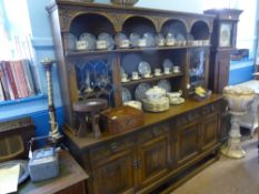 An Old Charm oak dresser having an open shelf to the top with arched decoration, an astral glazed