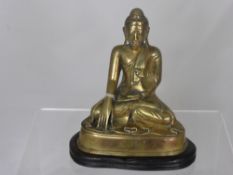 An Antique Brass Buddha Statuette, depicted seated in a contemplative pose, supported on a fruit