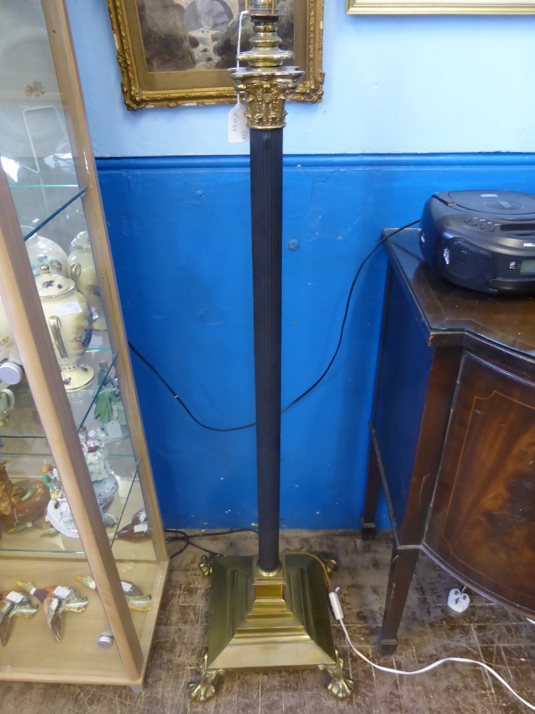 A classical style corinthian standard lamp on claw feet.