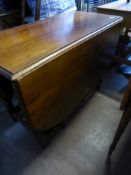 A Victorian mahogany gate leg dining table on part turned legs, rounded corners to the table top,