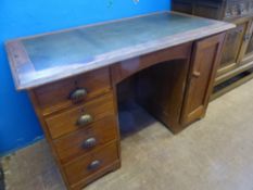 A vintage pine desk having a tooled green leather insert to top, four graduated drawers to one side