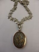 A silver and gold locket with silver necklace.